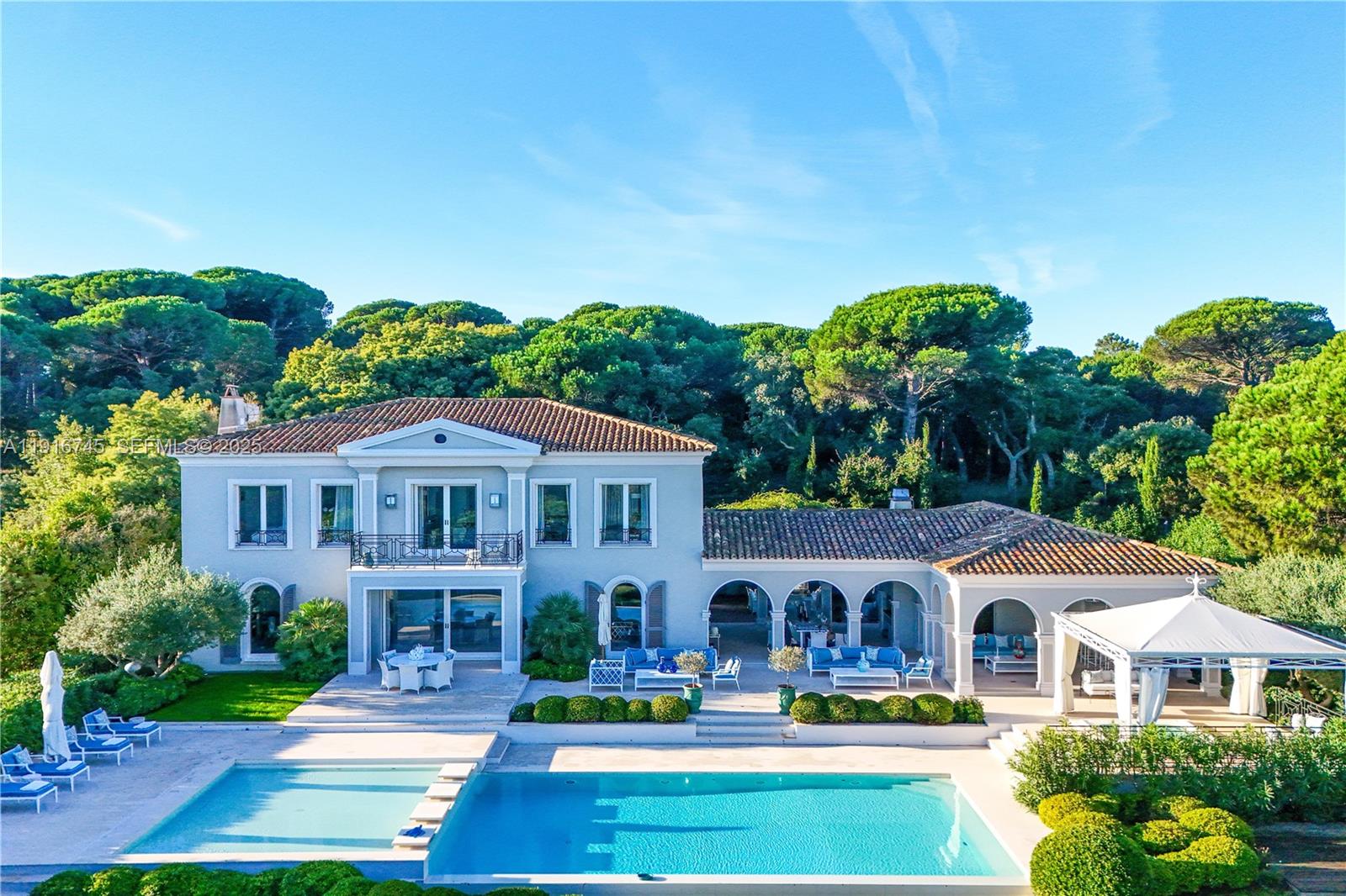 An aerial view of a two-story Mediterranean-style villa with a pool and covered patio — La quessine Le Paradis, FL, FL