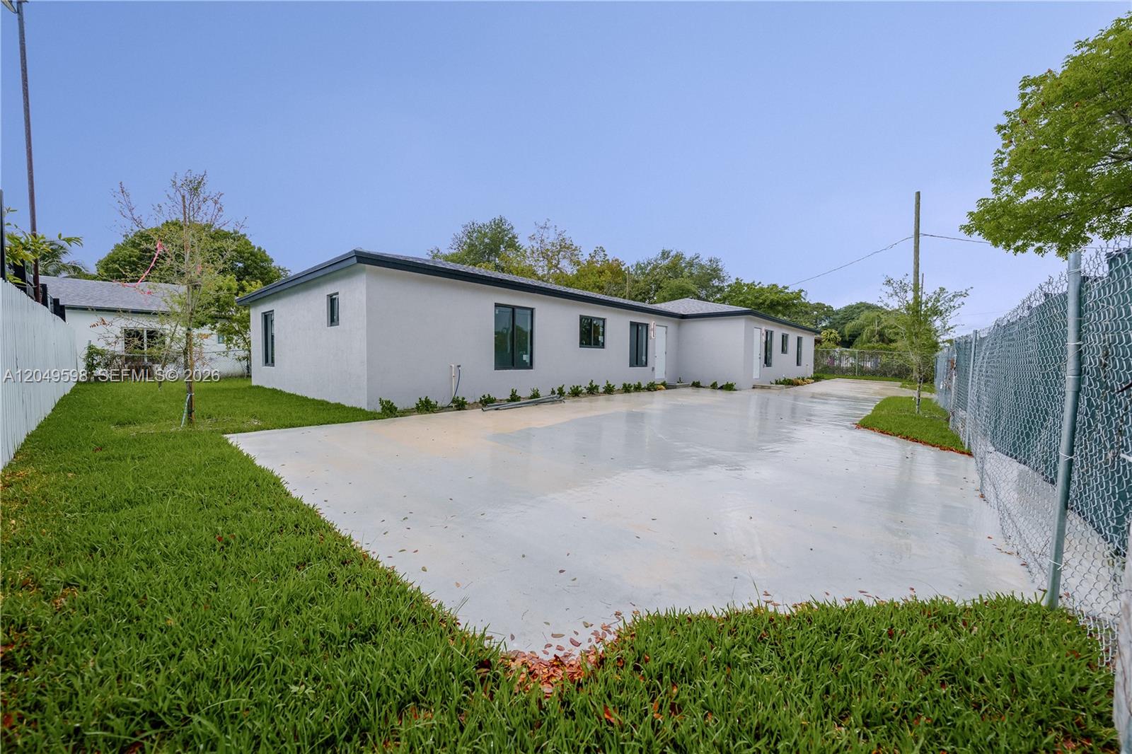 A single-story house with a concrete driveway and a chain-link fence on the side — 1112 NW 81st St, Miami FL 33150, MIAMI, FL