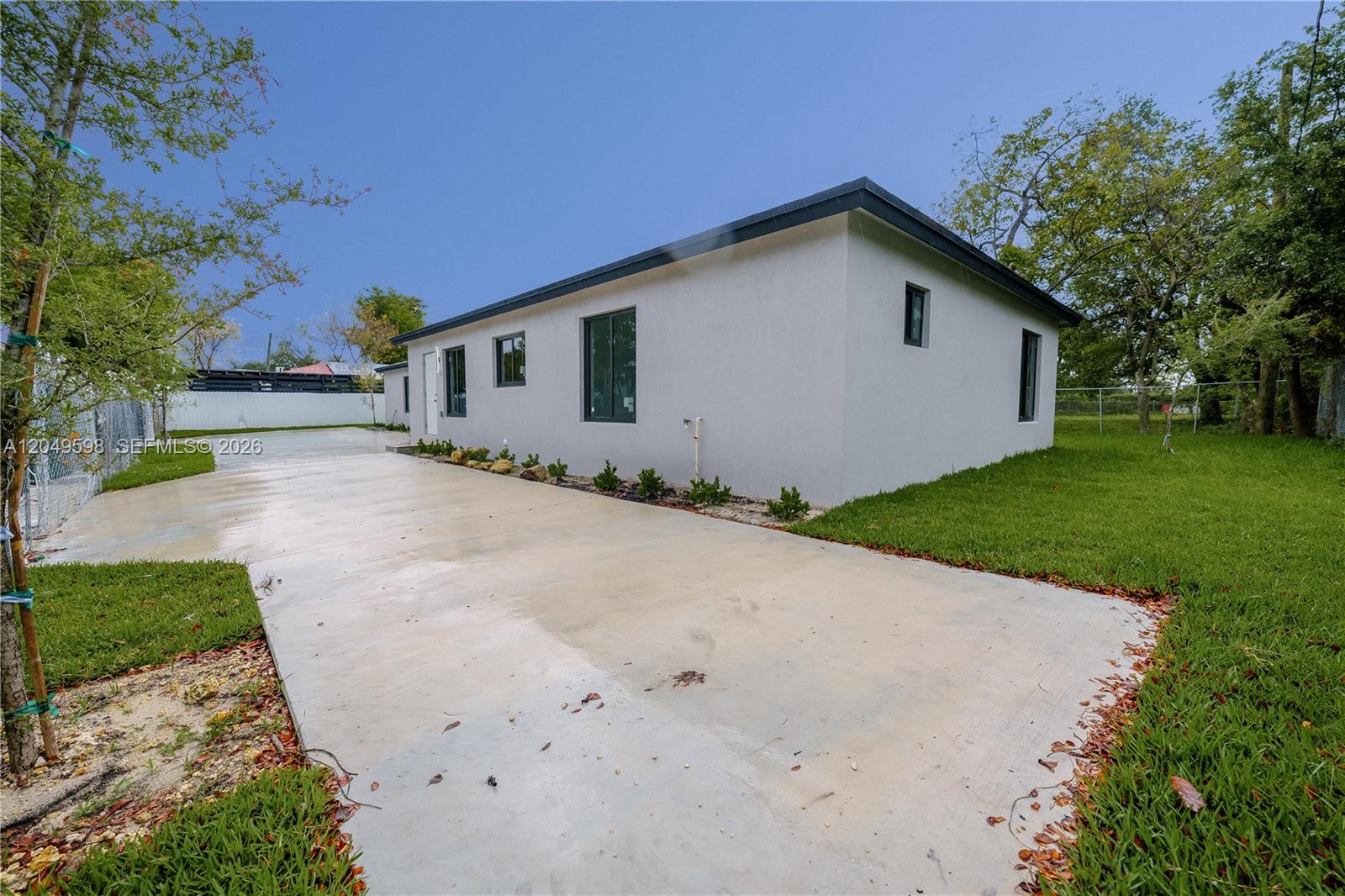 A single-story house with a white stucco exterior and a concrete driveway — 1112 NW 81st St, Miami FL 33150, MIAMI, FL