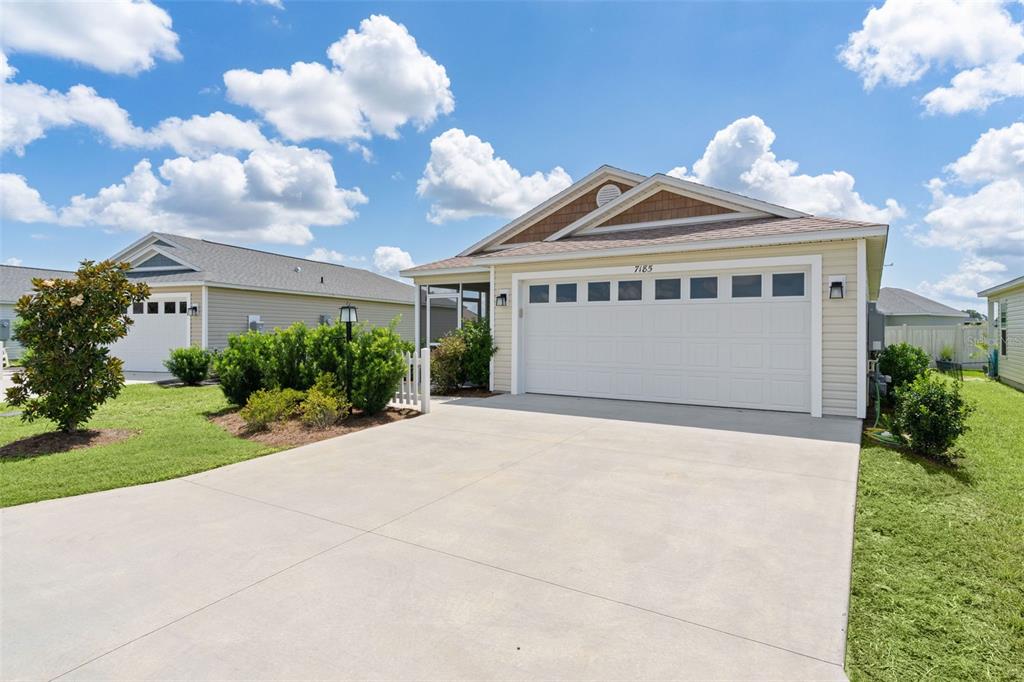 A single-story suburban house with a two-car garage and a concrete driveway — 7185 FAY COURT, THE VILLAGES, FL