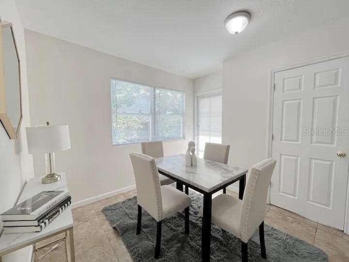 A dining room features a marble-topped table, four upholstered chairs, and a gray area rug — 3606 W BAY TO BAY BOULEVARD, TAMPA, FL