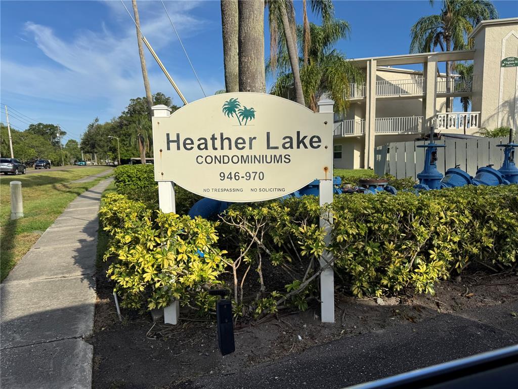 A sign for Heather Lake Condominiums stands in front of a multi-story apartment building — 946 VIRGINIA STREET UNIT 104, DUNEDIN, FL