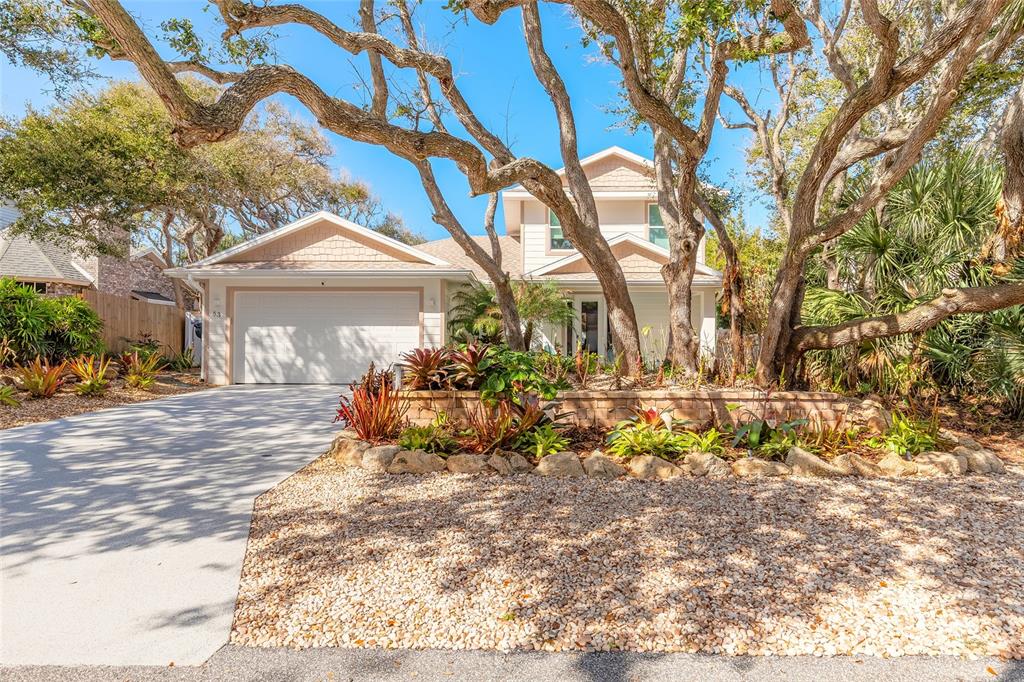 A two-story house with a garage, gravel landscaping, and large trees in the front yard — 68 GLENVIEW AVENUE, PONCE INLET, FL