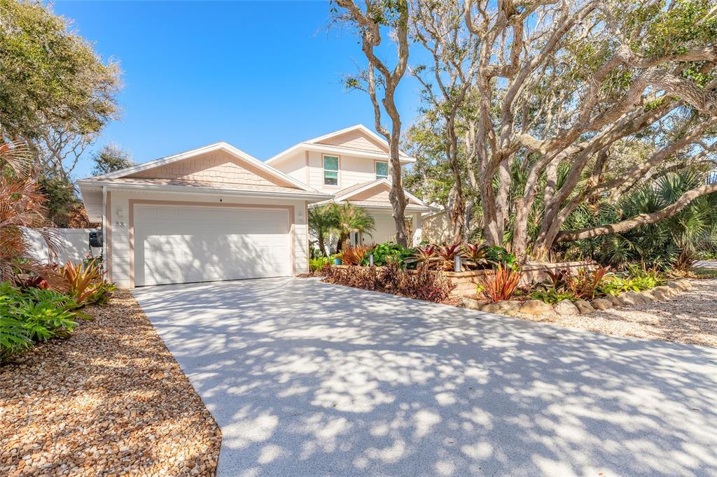 A two-story house with a white garage, a concrete driveway, and mature trees — 68 GLENVIEW AVENUE, PONCE INLET, FL