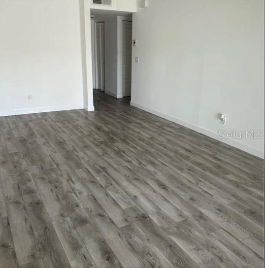 An empty room features gray wood-look laminate flooring and white walls — 9700 STARKEY ROAD UNIT 322, SEMINOLE, FL