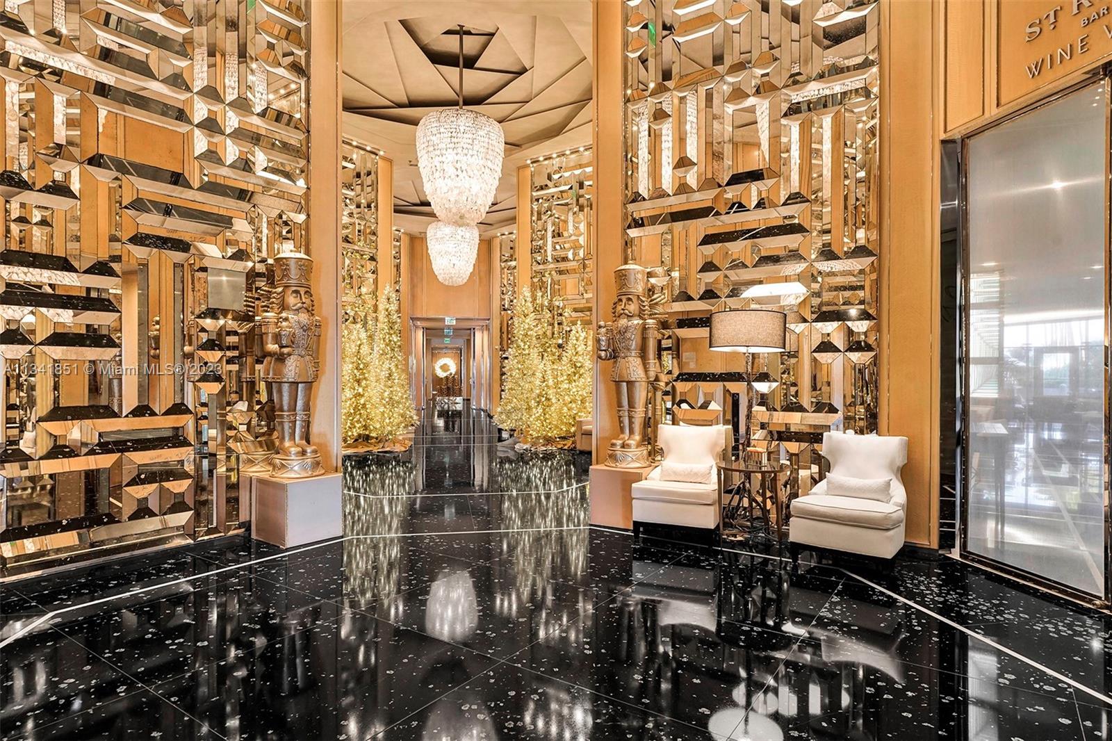A luxurious lobby features mirrored walls, two large nutcracker statues, and white armchairs on flooring — 9703 Collins Ave # 2501, Bal Harbour FL 33154, BAL HARBOUR, FL