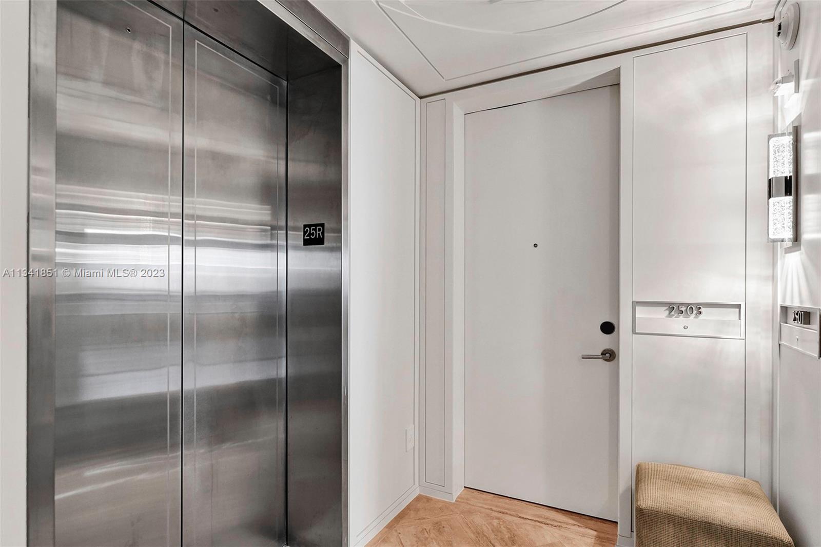 A hallway features a stainless steel elevator, a white door labeled 2503, and wood flooring — 9703 Collins Ave # 2501, Bal Harbour FL 33154, BAL HARBOUR, FL
