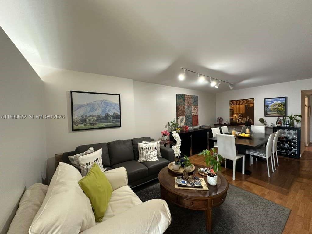 A living and dining area features a dark sofa, a round coffee table, and chairs — 1000 Parkview Dr # 627, Hallandale Beach FL 33009, HALLANDALE BEACH, FL