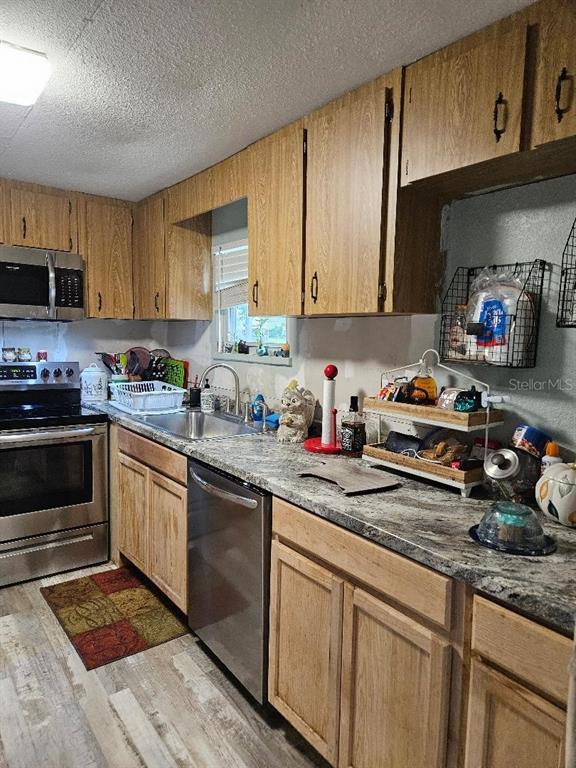 A kitchen features wood cabinets, stainless steel appliances, and granite-look countertops — 425 ORANGE BOULEVARD, POLK CITY, FL