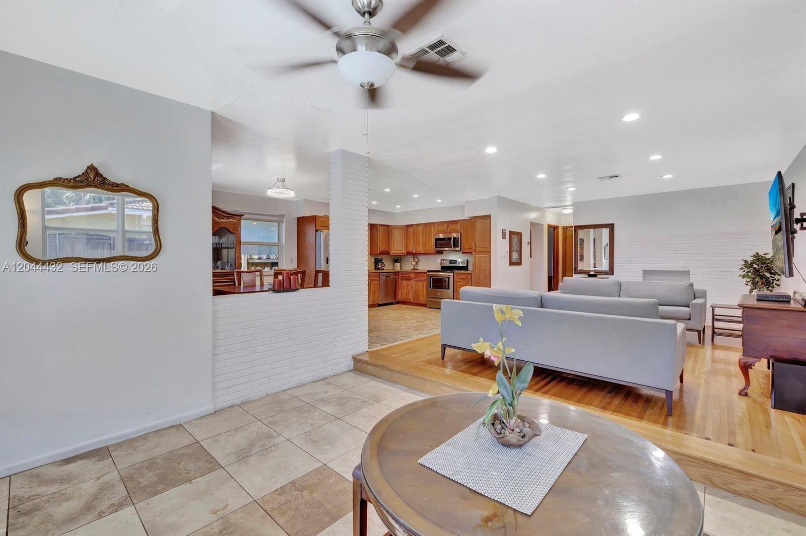 An open-concept living room and kitchen feature a sunken seating area with hardwood floors — 45 SE 14th St, Dania Beach FL 33004, DANIA BEACH, FL