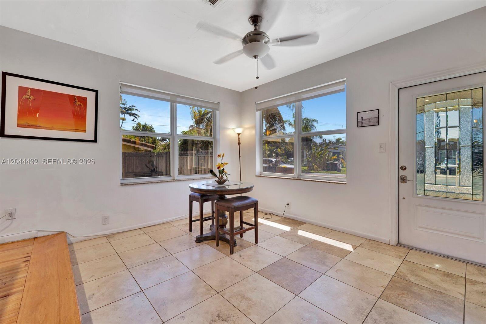 A sunlit breakfast nook features tile flooring, a small round table, and a ceiling fan — 45 SE 14th St, Dania Beach FL 33004, DANIA BEACH, FL