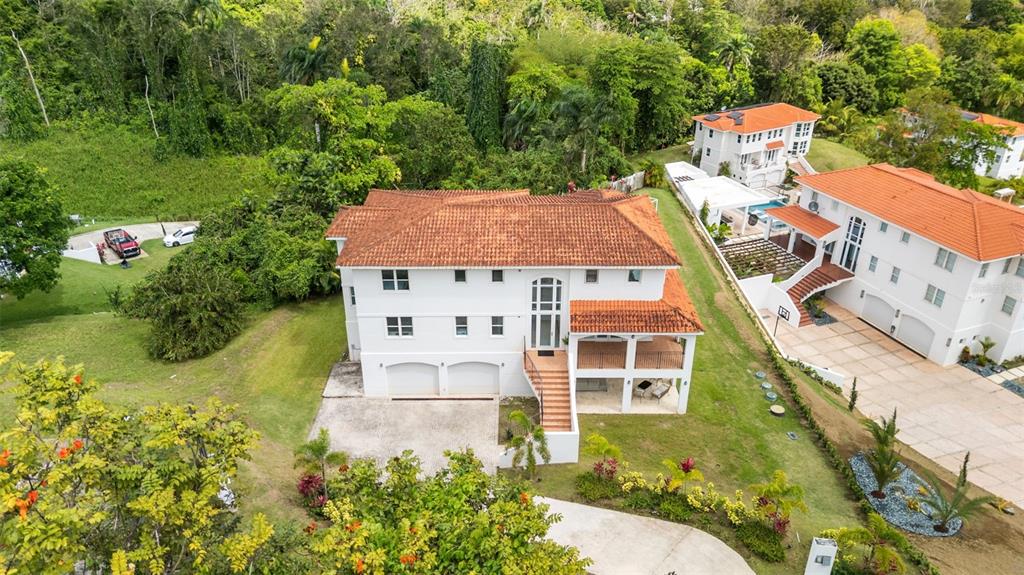 An aerial view shows a multi-story white house with a red tile roof and garage — Carretera PR-175 KM. 4.0 ESMERALD LAKE PLANTATION UNIT E-3, TRUJILLO ALTO, PR