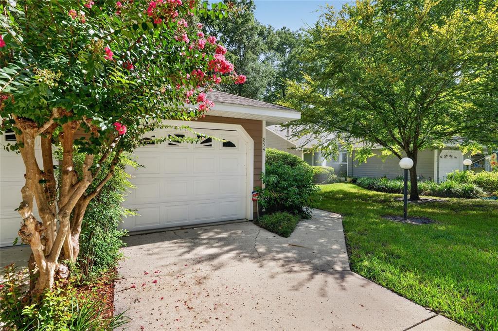 A white garage door is attached to a house with a concrete driveway and landscaping — 854 SW 51ST WAY, GAINESVILLE, FL
