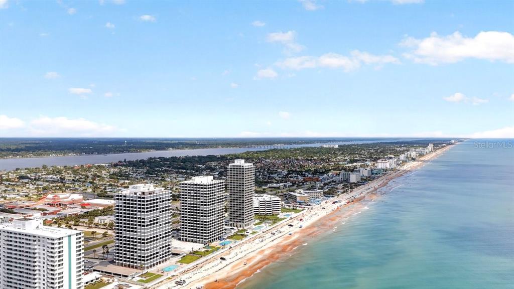 An aerial view shows high-rise buildings along a sandy beach bordering the ocean — 2900 N ATLANTIC AVENUE UNIT 1006, DAYTONA BEACH, FL