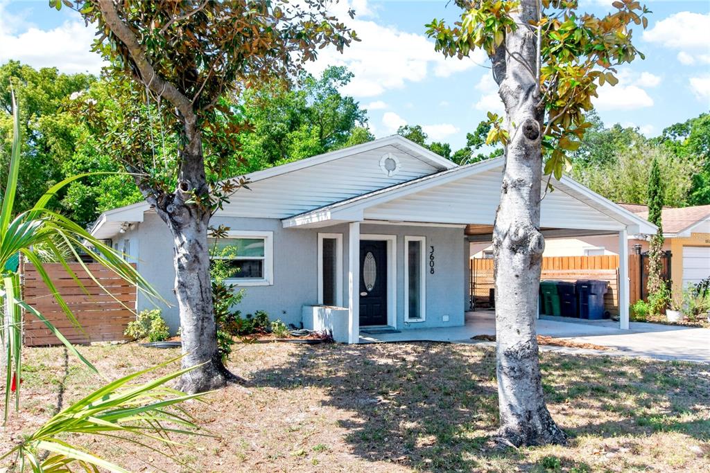 A single-story house with a light gray exterior, a front porch, and a carport — 3608 W CARMEN STREET, TAMPA, FL