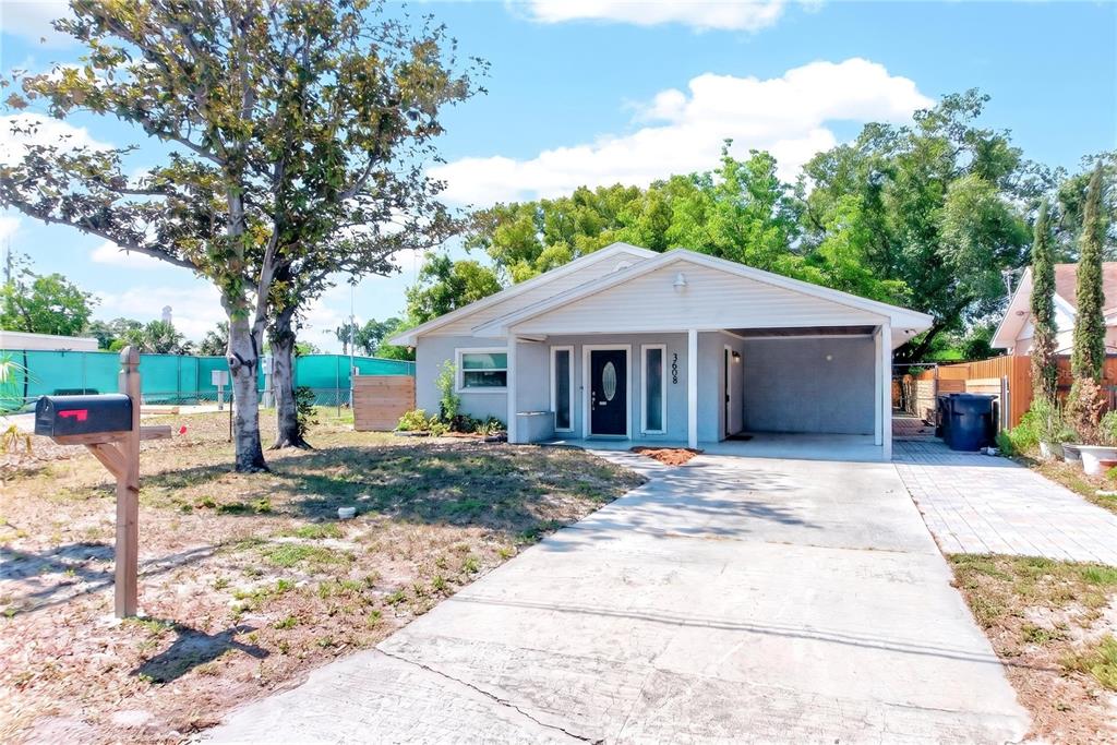 A single-story house with a gray exterior, a front carport, and a concrete driveway — 3608 W CARMEN STREET, TAMPA, FL