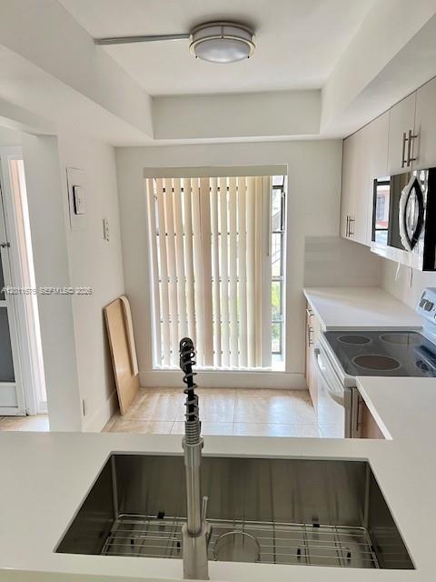 A kitchen features a stainless steel sink, white countertops, light cabinetry, and a window with blinds — 2355 SW 15th St # 73, Deerfield Beach FL 33442, DEERFIELD BEACH, FL