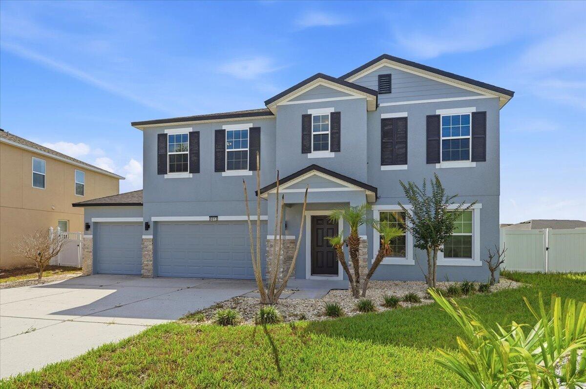 A two-story blue house with a three-car garage and a front porch — 9012 Orange Blossom Loop, FL 33844, FL