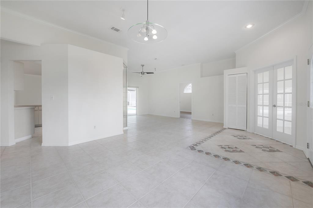 An open-concept living area features light tile flooring, a chandelier, and white double doors — 15121 HEATHRIDGE DRIVE, TAMPA, FL