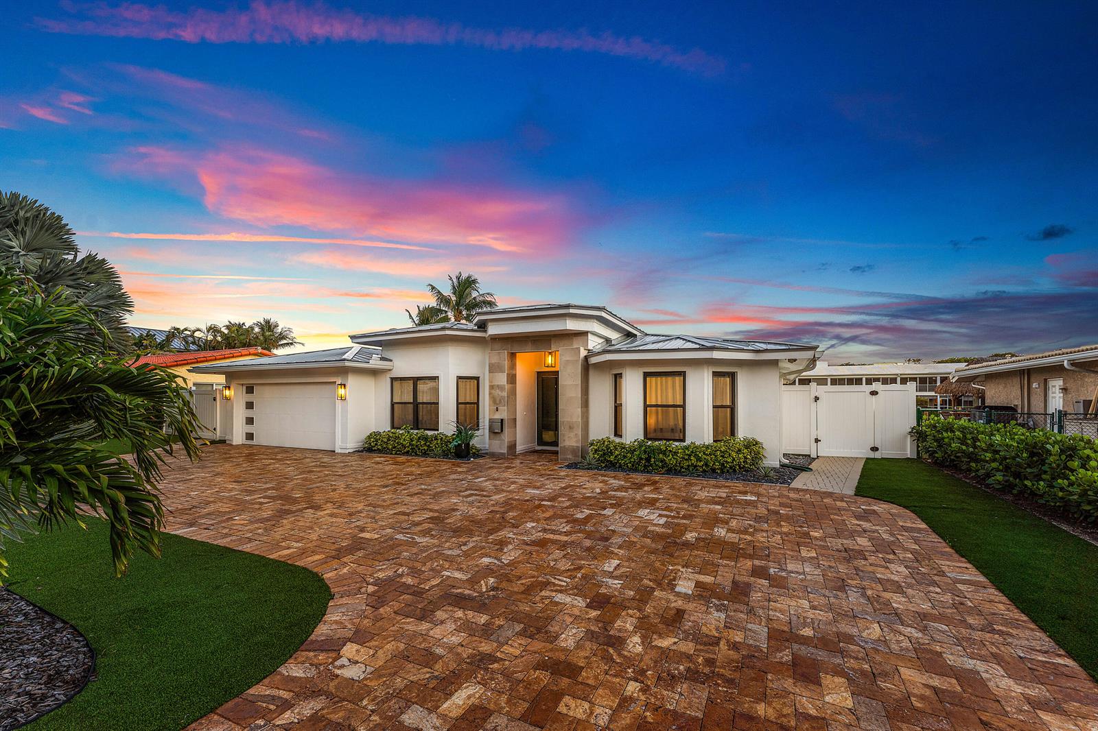 A modern single-story house with a paved driveway, white stucco walls, and a metal roof — 680 NE Harbour Drive, Boca Raton FL 33431, BOCA RATON, FL