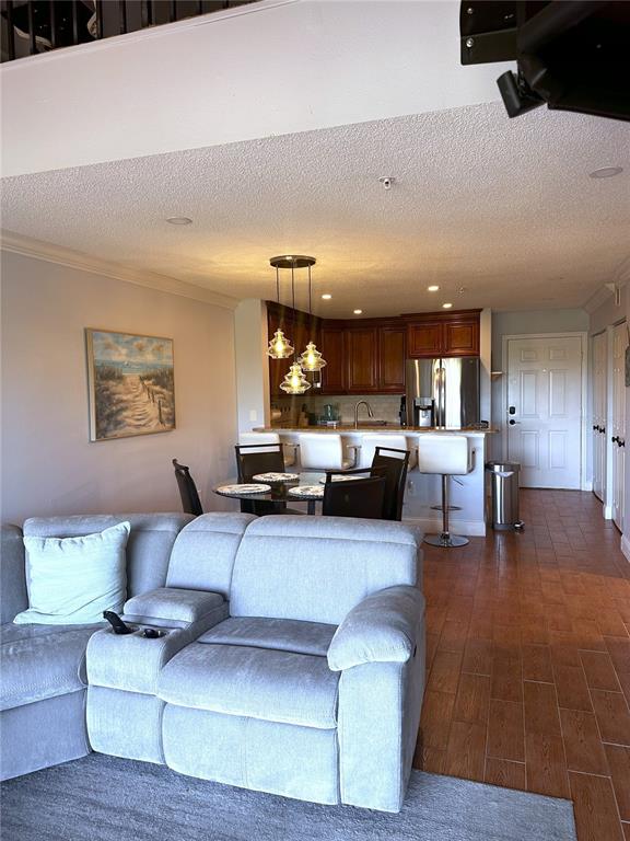 A dining area with a glass table and pendant lights sits beside a living room — 2400 FEATHER SOUND DRIVE UNIT 534, CLEARWATER, FL
