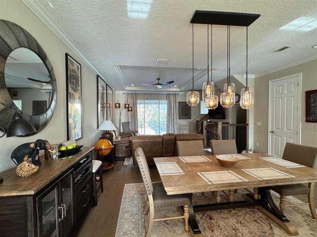 A dining room with a wooden table and pendant lights opens into a living area — 1487 LAKE GEORGE DRIVE, LAKE MARY, FL