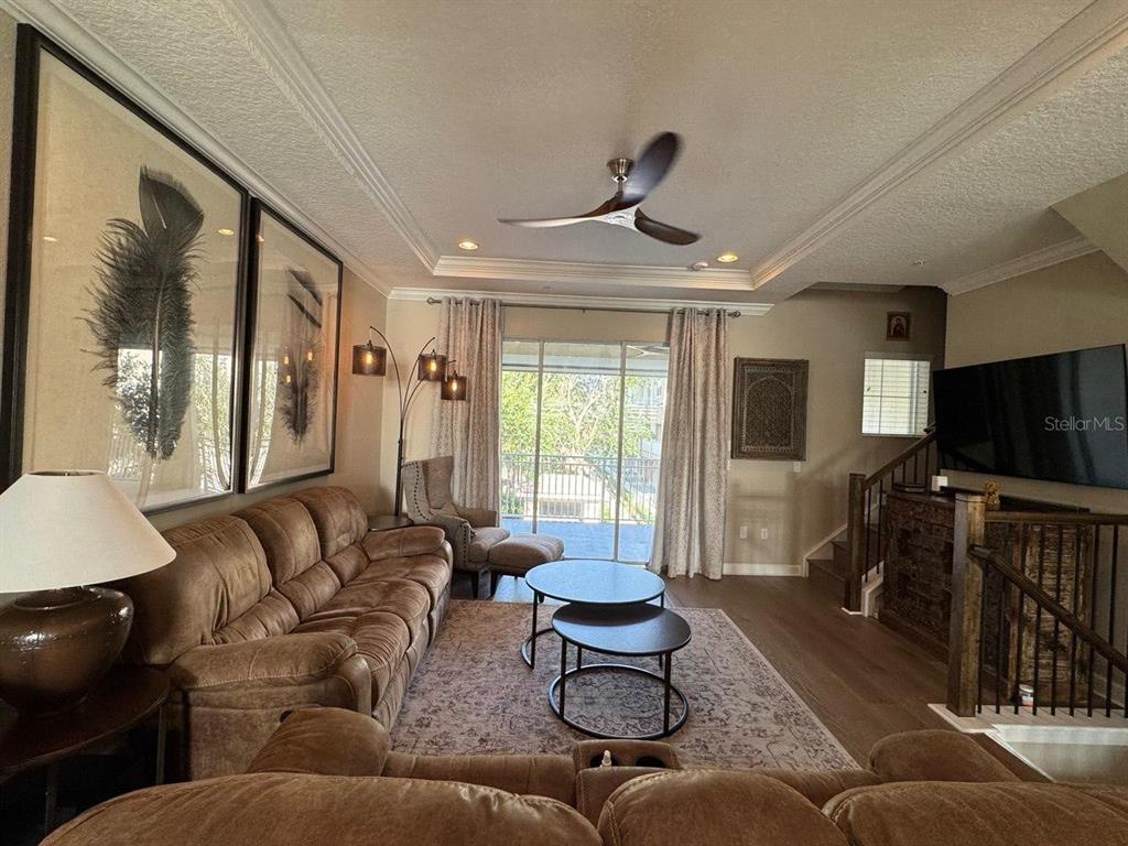 A living room features a brown sofa, two round coffee tables, and a ceiling fan — 1487 LAKE GEORGE DRIVE, LAKE MARY, FL