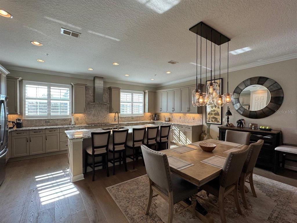 A kitchen and dining area with light cabinetry, a central island, and a pendant light fixture — 1487 LAKE GEORGE DRIVE, LAKE MARY, FL