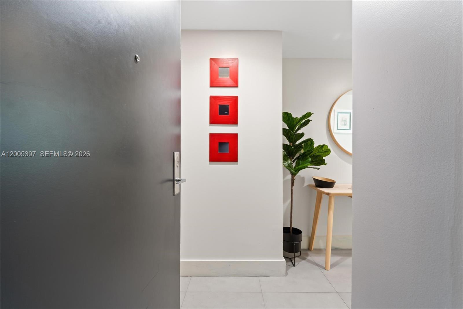An entryway features a gray door, three red square wall decorations, and a potted plant — 500 Brickell Ave # 1405, Miami FL 33131, MIAMI, FL