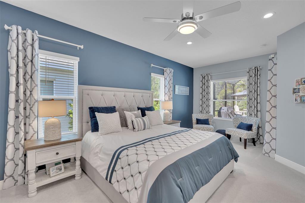 A bedroom features a tufted headboard, blue accent wall, two nightstands, and a ceiling fan — 3321 WOODMONT DRIVE, PARRISH, FL