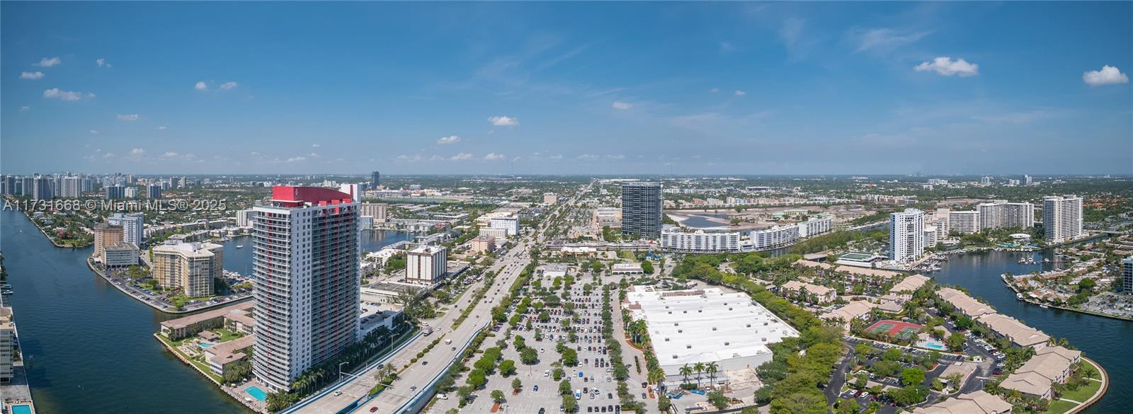 An aerial view shows a high-rise building, a large parking lot, and surrounding suburban development — 4010 S Ocean Dr # T3502, Hollywood FL 33019, HOLLYWOOD, FL
