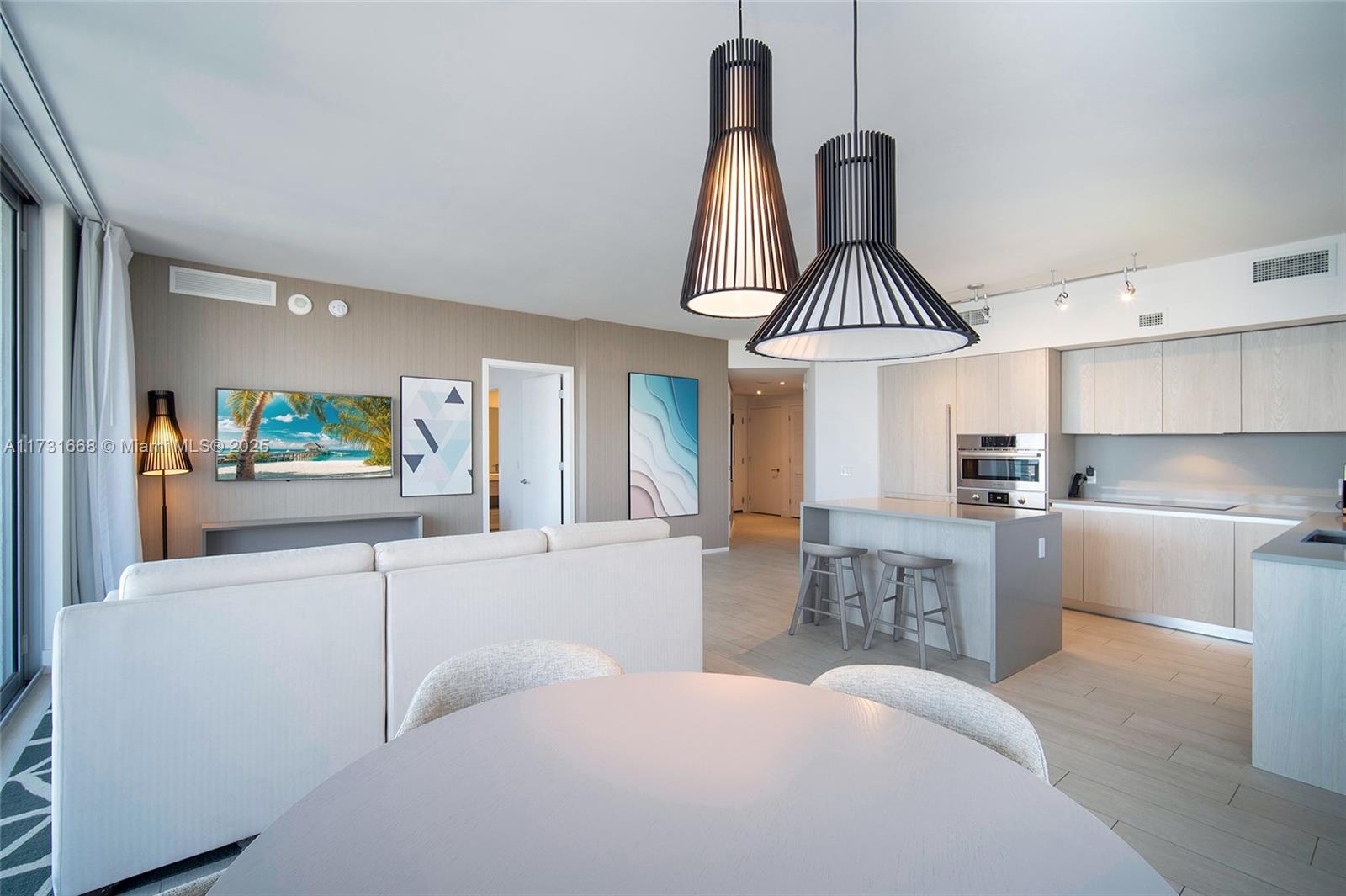 A modern open-concept living area features a kitchen with an island and a dining space — 4010 S Ocean Dr # T3502, Hollywood FL 33019, HOLLYWOOD, FL