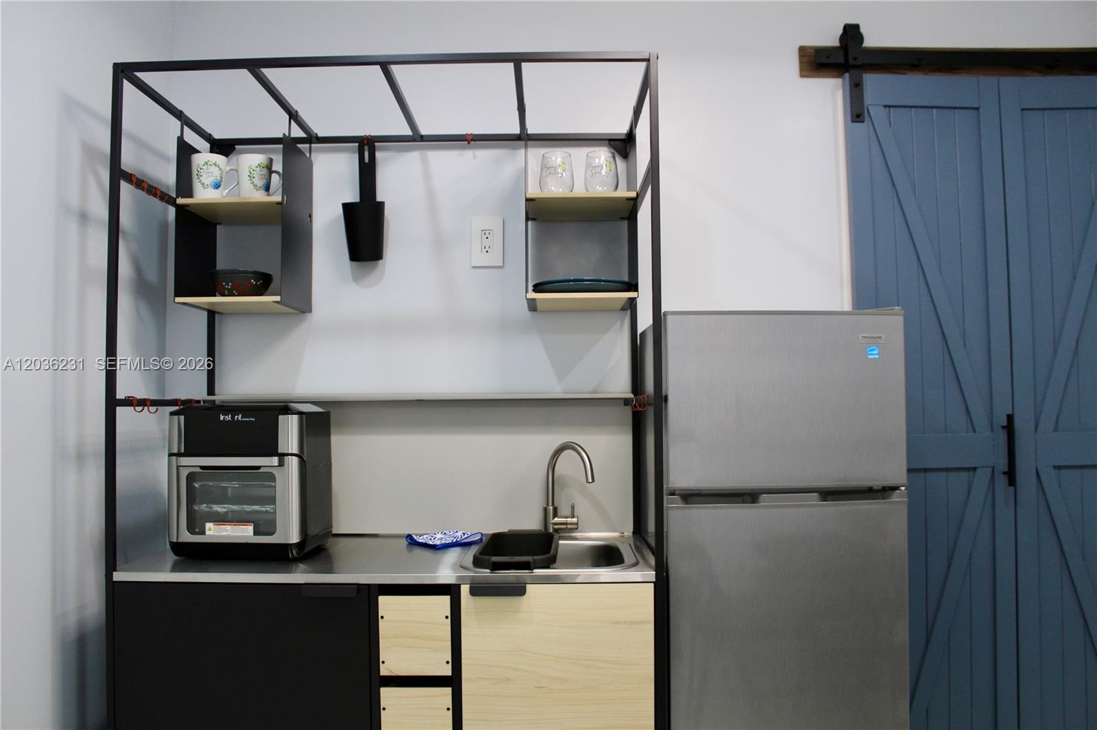 A kitchenette features a metal frame shelving unit, stainless steel sink, and a small refrigerator — 14670 SW 150th St # A, Miami FL 33186, MIAMI, FL