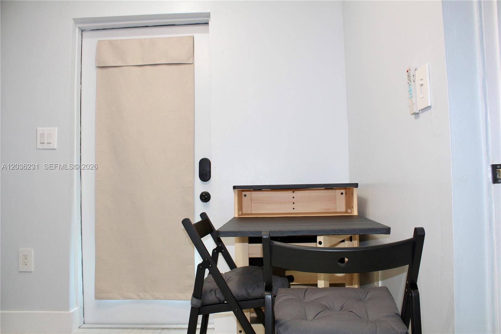 A small dining area features a folding table with two chairs near a door — 14670 SW 150th St # A, Miami FL 33186, MIAMI, FL