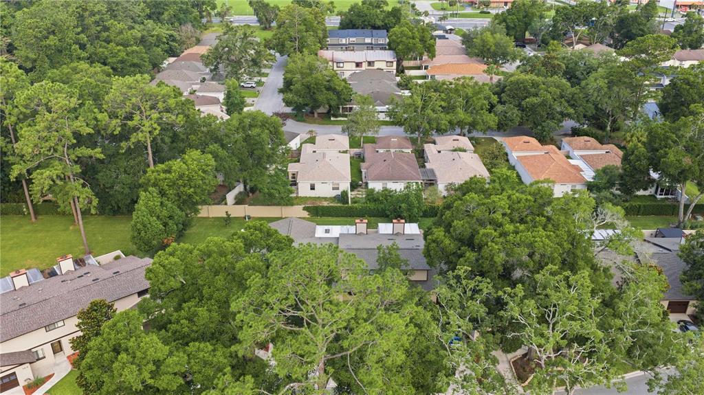 An aerial view shows a residential neighborhood with houses, lush green trees, and paved streets — 3824 NE 19TH STREET CIRCLE, OCALA, FL