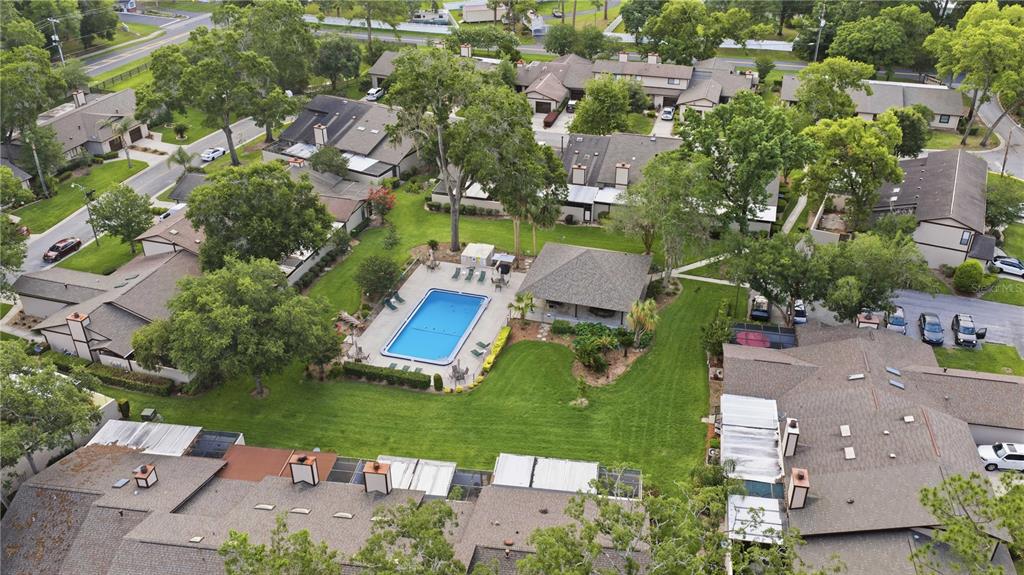 An aerial view shows a community swimming pool surrounded by townhomes and lush green trees — 3824 NE 19TH STREET CIRCLE, OCALA, FL
