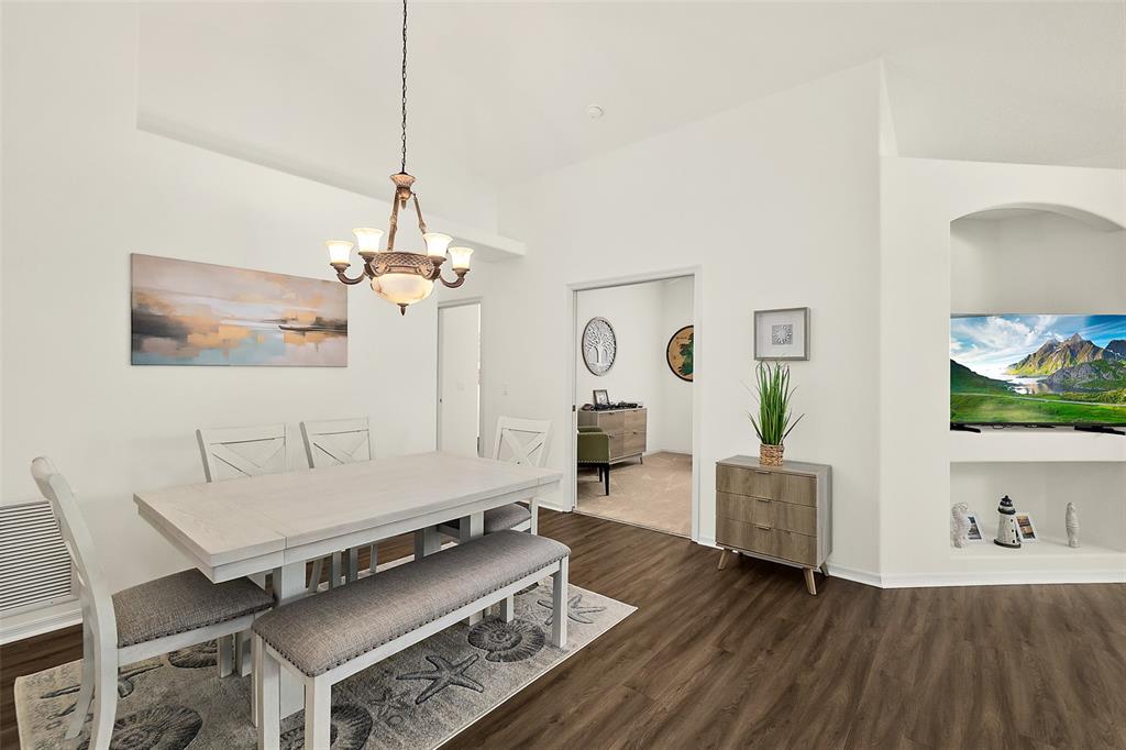 A dining area with a light wood table, bench seating, and a built-in media niche — 17 ARBOR TRACE UNIT 17, PALM COAST, FL