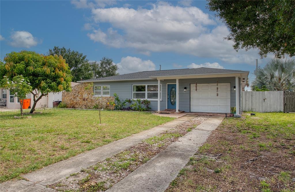 A single-story house with gray siding, a stone accent wall, and a two-track concrete driveway — 5213 97TH WAY N, ST PETERSBURG, FL
