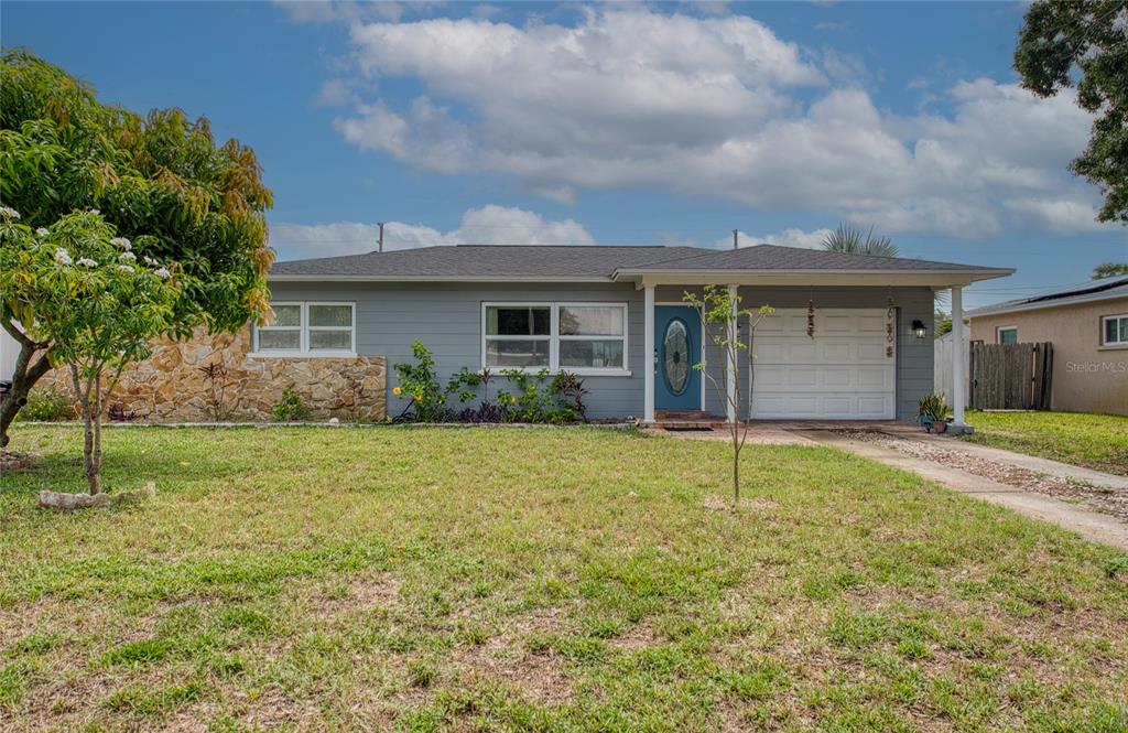 A single-story house with gray siding, a stone facade, and an attached garage — 5213 97TH WAY N, ST PETERSBURG, FL