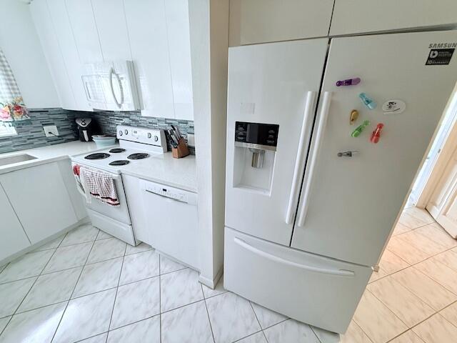 A white kitchen features a refrigerator, stove, dishwasher, and tiled floors — 41 Upminster B Crescent # B, Deerfield Beach FL 33442, DEERFIELD BEACH, FL