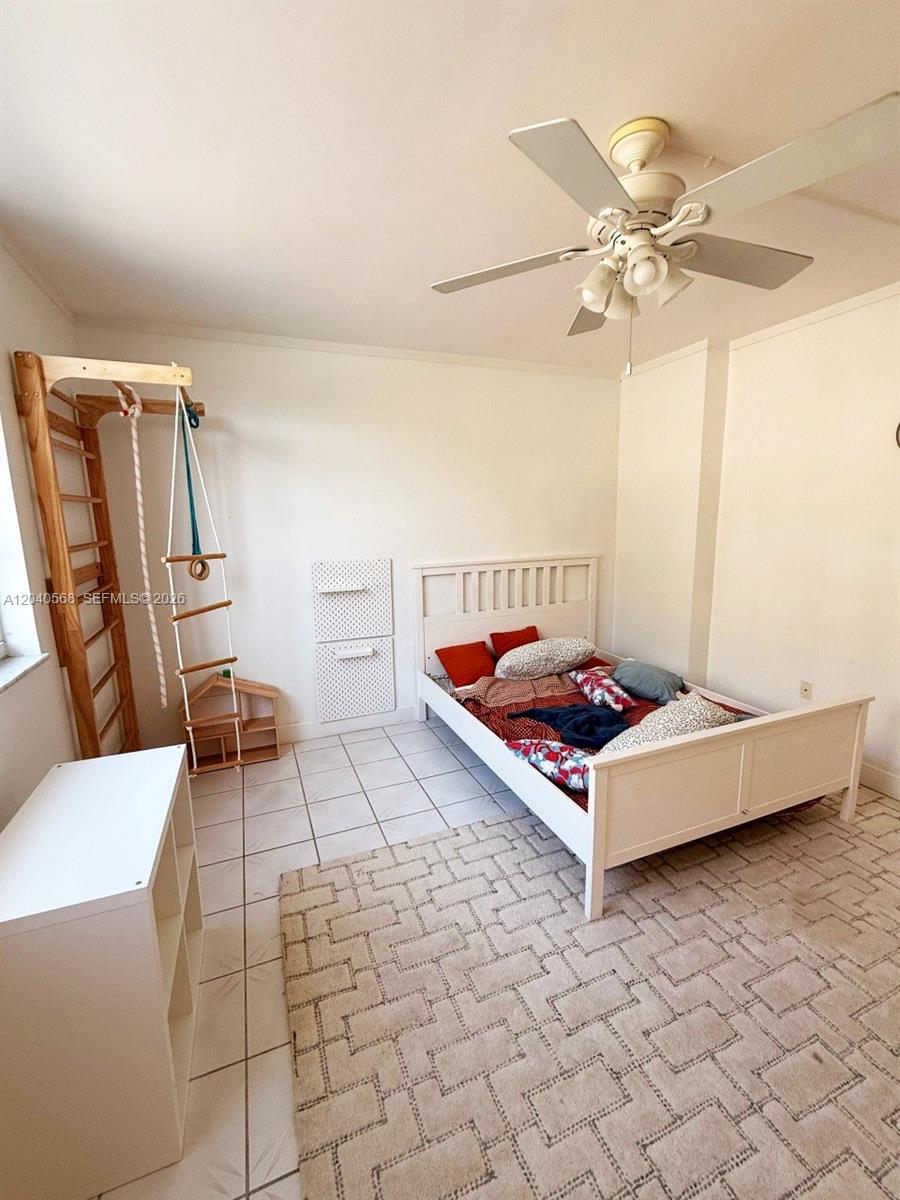 A bedroom features a white bed, a wooden climbing frame, and a patterned area rug — 1701 S Ocean Dr # 105, Hollywood FL 33019, HOLLYWOOD, FL