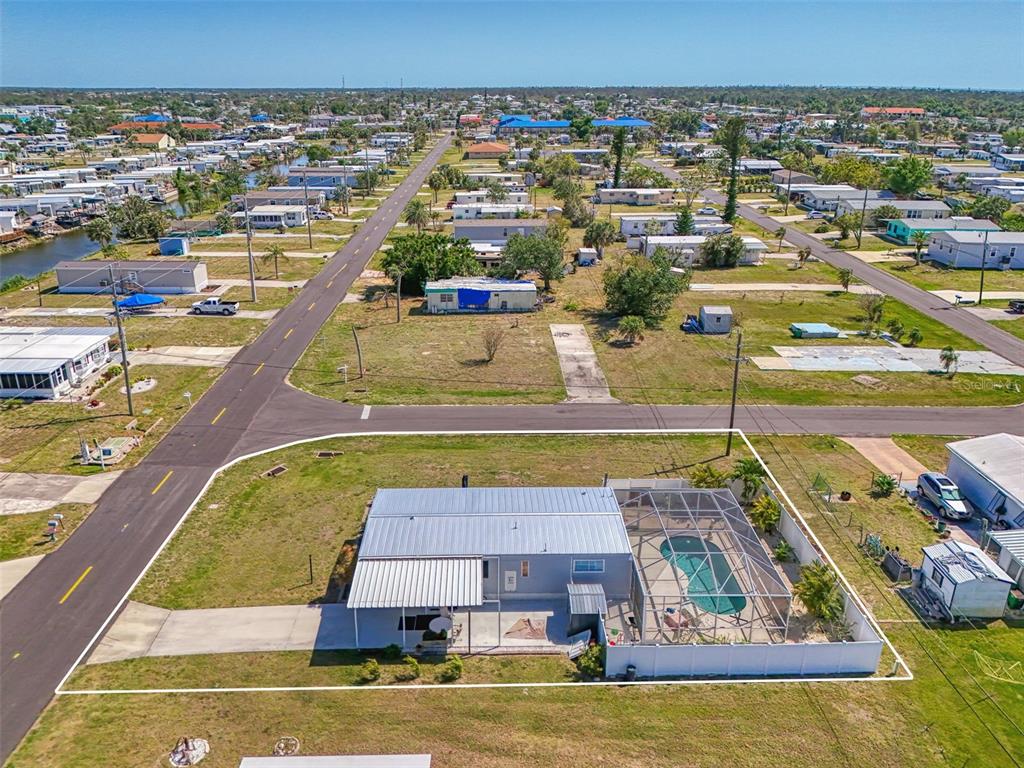 An aerial view shows a single-story house with a screened-in pool and a metal roof — 1376 FLAMINGO DRIVE, ENGLEWOOD, FL