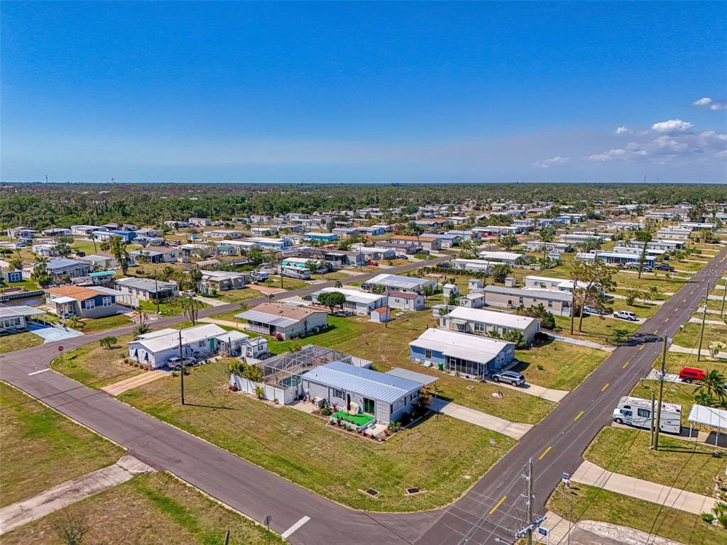 An aerial view shows a residential neighborhood with numerous manufactured homes and paved streets — 1376 FLAMINGO DRIVE, ENGLEWOOD, FL