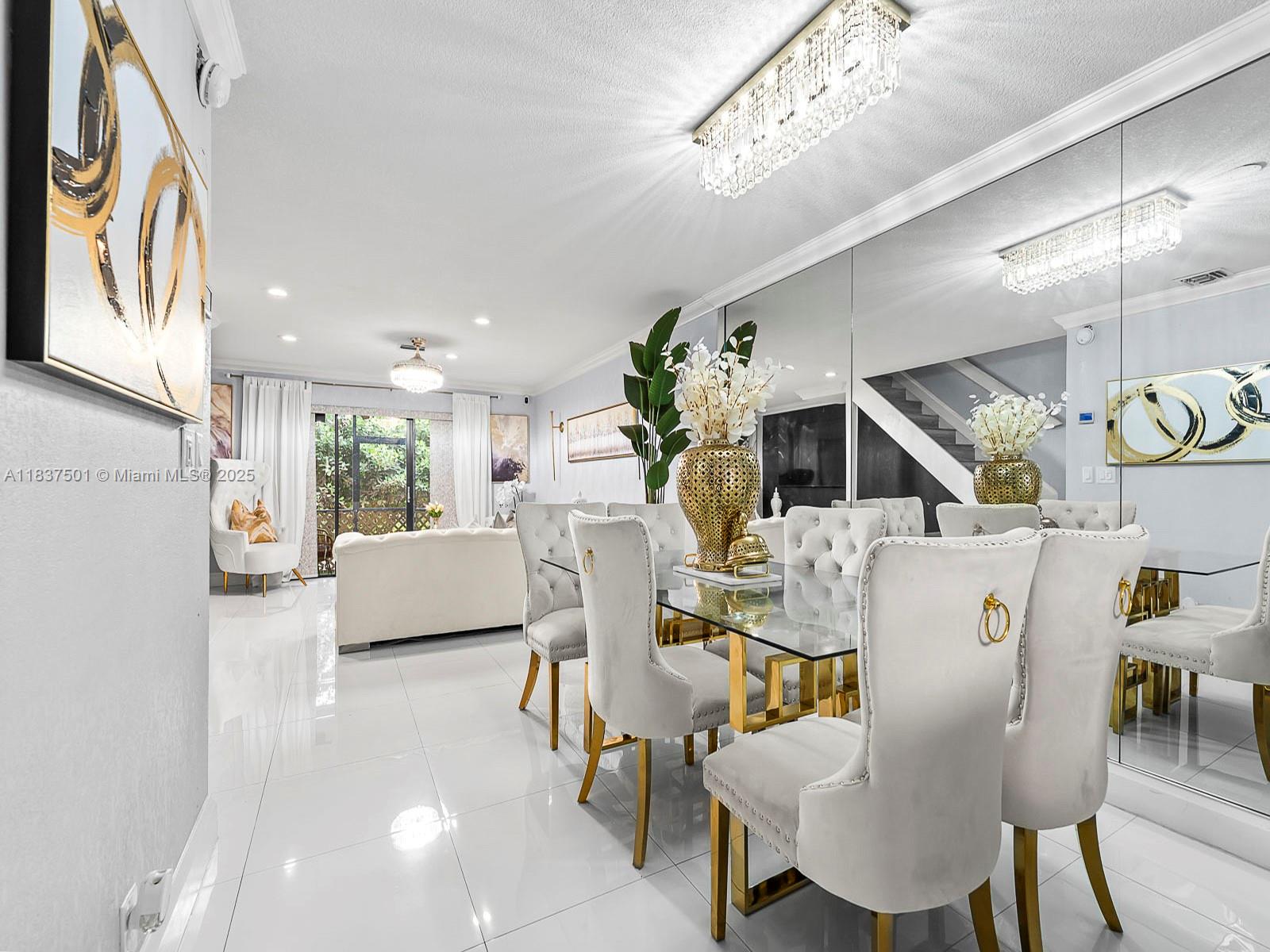 A dining area with a glass table, white tufted chairs, and mirrored walls — 10942 W Sample Rd # E1, Coral Springs FL 33065, CORAL SPRINGS, FL