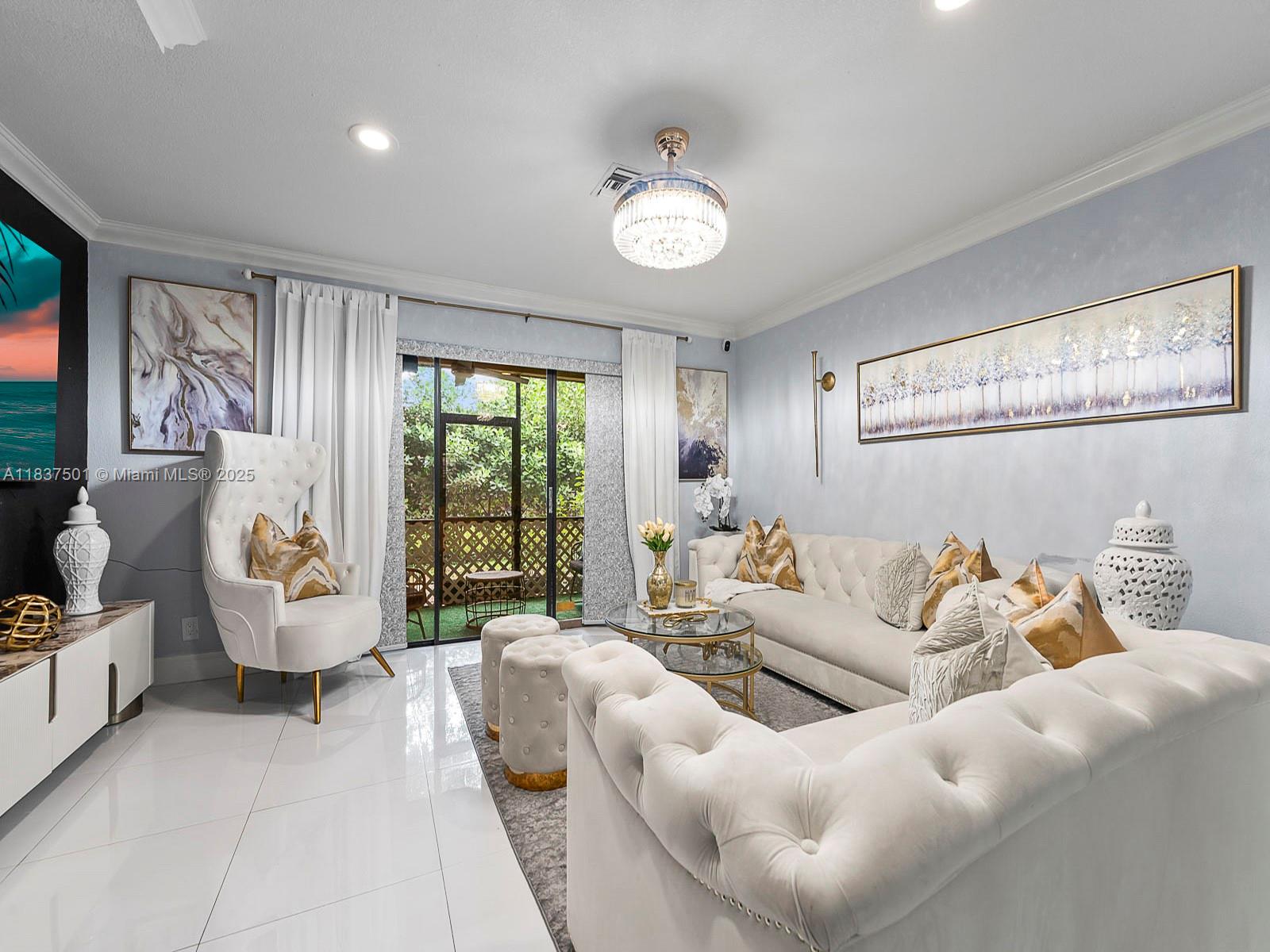 A living room features white tufted sofas, a high-back chair, and a glass coffee table — 10942 W Sample Rd # E1, Coral Springs FL 33065, CORAL SPRINGS, FL