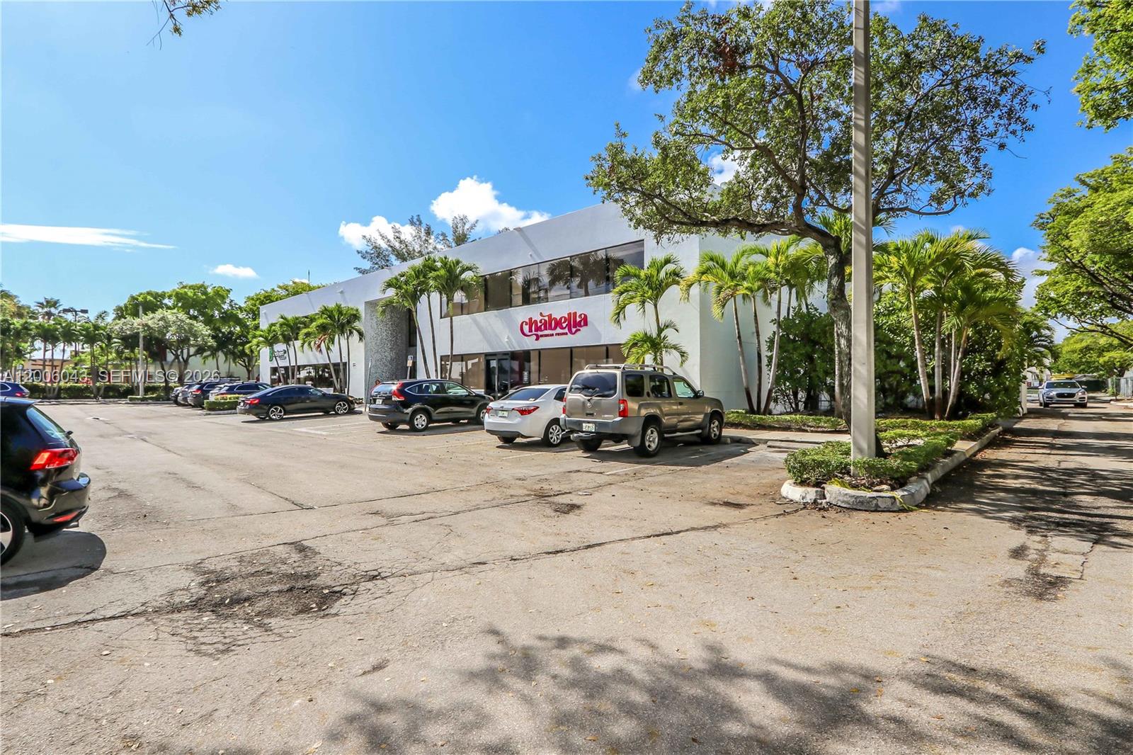 A two-story commercial building with a parking lot and palm trees in front — 7910 NW 25th St # 207, Doral FL 33122, DORAL, FL