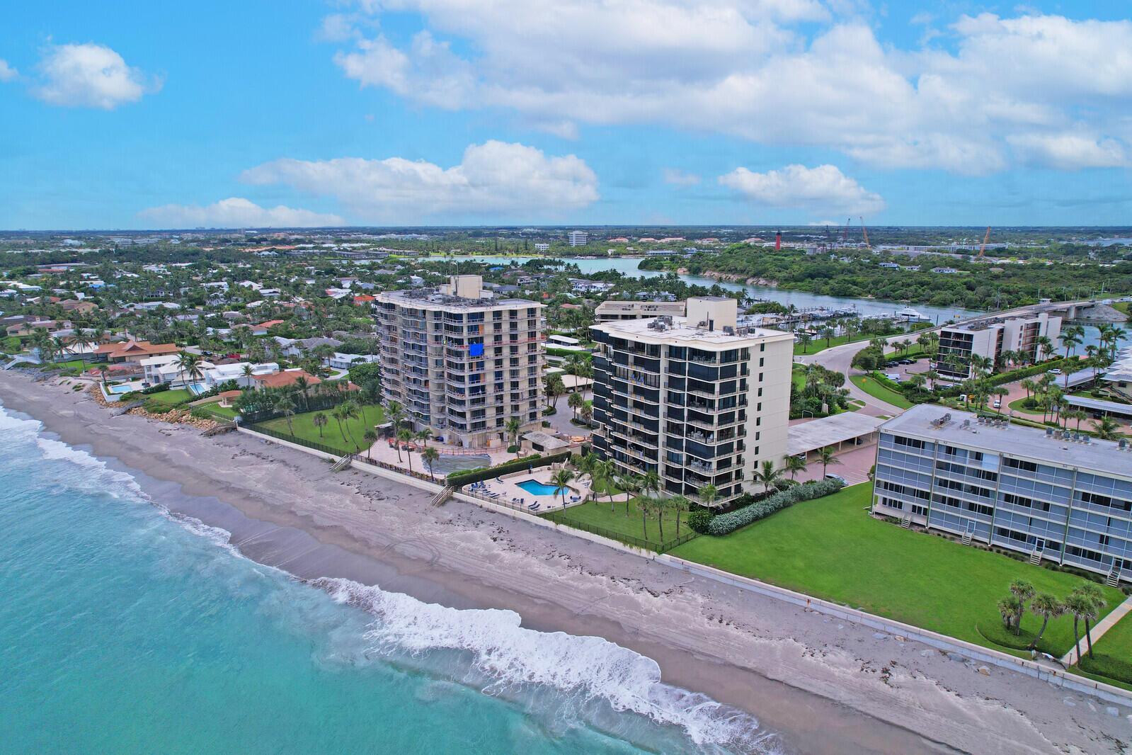 An aerial view shows three beachfront high-rise apartment buildings along a sandy coastline — 200 S Beach Road # 802, Tequesta FL 33469, TEQUESTA, FL