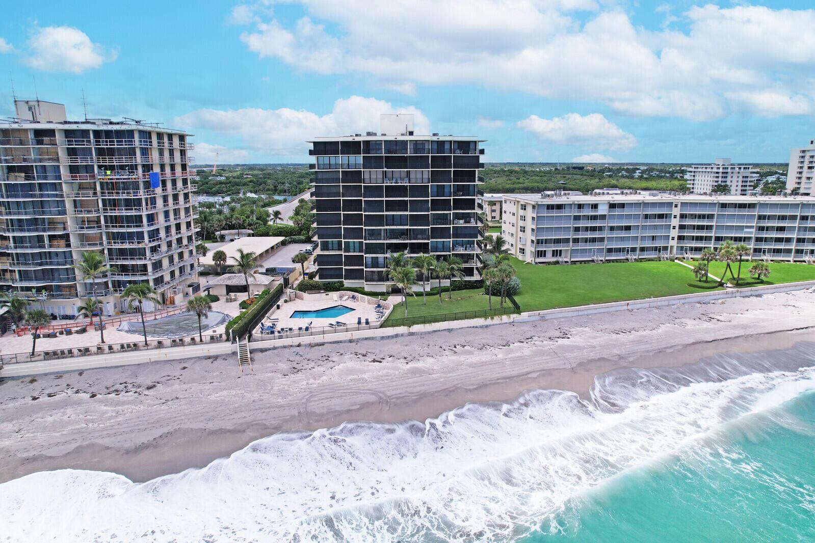 An aerial view of beachfront apartment buildings with swimming pools and a sandy shoreline — 200 S Beach Road # 802, Tequesta FL 33469, TEQUESTA, FL