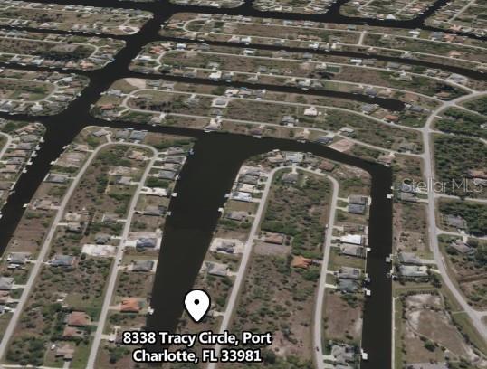 This is an aerial map view of a residential neighborhood with houses along a canal — 8338 TRACY CIRCLE, PORT CHARLOTTE, FL