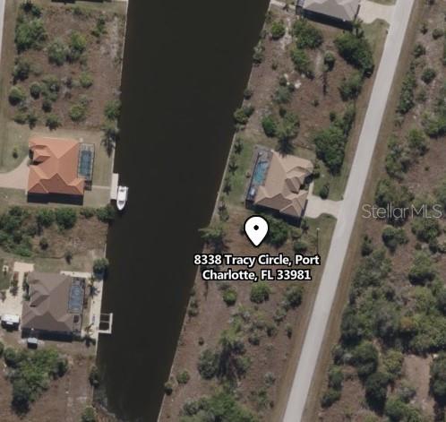 This aerial map view shows a house with a pool situated along a canal — 8338 TRACY CIRCLE, PORT CHARLOTTE, FL
